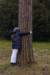 Contact with nature - a woman hugging a tree