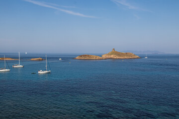 Sailing boats having dropped anchor near the coast of Corsica in a translucent, clear and calm Mediterranean sea