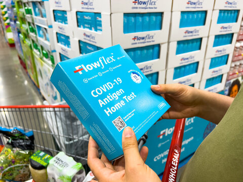 Sacramento, CA, USA March 25th, 2022 Shoppers hands holding a box containing Flowflex brand Covid-19 Antigen Home test at a local discount warehouse store