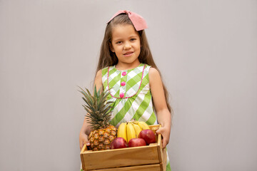 niños felices niña niño cargando canasta de rica fruta piña plátano banana manzana posando y disfrutando - obrazy, fototapety, plakaty