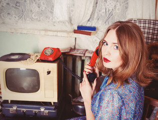 portrait of Old fashioned woman in USSR style talking on the old telephone in retro interior