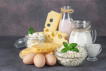 Dairy Products, Milk, Yogurt, Sour Cream, Several Types of Cheese, Curd and Eggs on Dark Gray Table