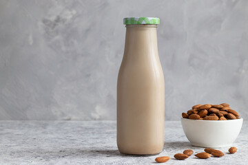 Almond milk and nuts in the bottle on the table. Vegan plant-based product. Healthy, and lactose free food concept. Selective focus