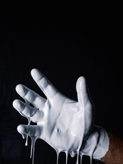 man's hand dripping white paint