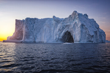 Fototapeta na wymiar Big icebergs floating over sea at sunset