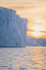 Big icebergs floating over sea at sunset
