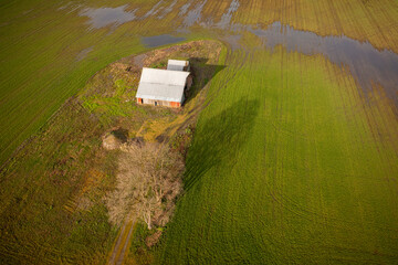 Aerial View of a Vintage Red Barn in the Middle of a Farm Field. Rural image of a classic old barn...