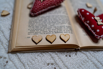 old open book with tiny wooden hearts