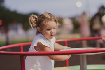 A little girl in modern summer clothes playing in the park in summer. Selective focus 