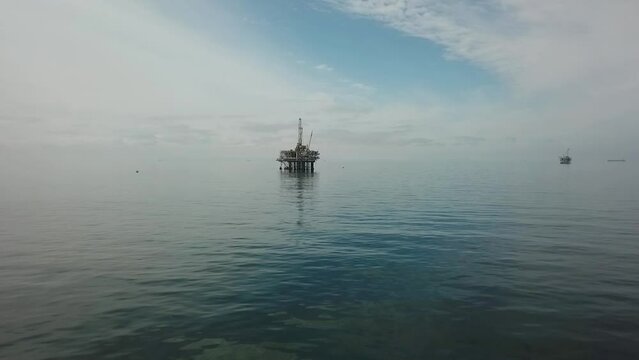Aerial view of off shore Industrial Oil Rig production drilling platforms extracting petroleum from the Pacific ocean