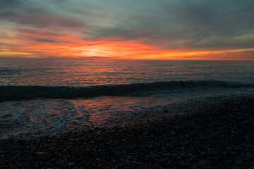 Ocean beach sunrise and dramatic colorful sky clouds. Dramatic sea sunrise. Burning sky and shining golden waves