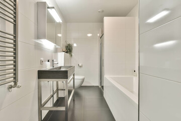 The interior of a cozy bathroom with a bathtub, shower, toilet and sink in a modern apartment