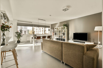 Interior of a cozy bright living room with a street view and a dining area in a modern house