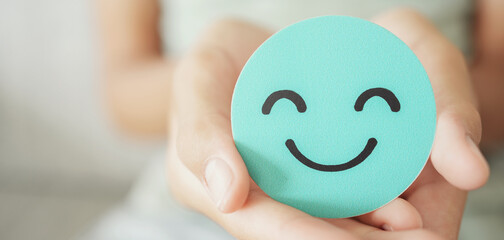 Hands holding green happy smile face paper cut, good feedback rating,think positive, customer...