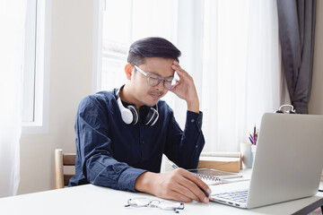 Obraz premium An Asian male businessman with stressful headaches from working on his desk.