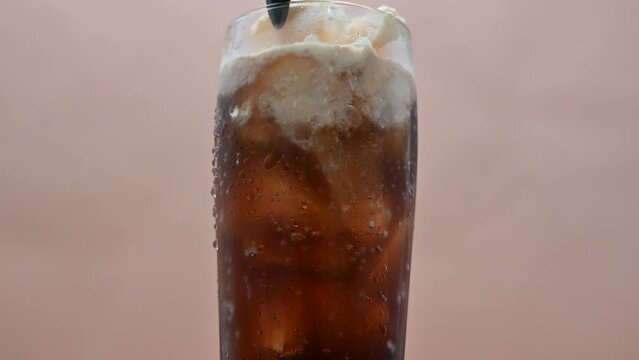 Stir the cola float with a muddler