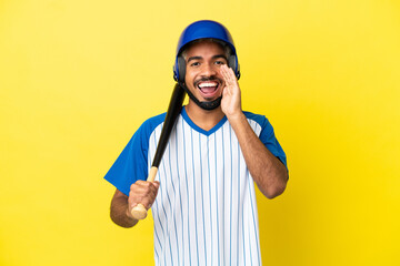 Young Colombian latin man playing baseball isolated on yellow background shouting with mouth wide open