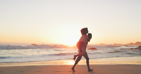 Fototapeta na wymiar Were running off into the sunset. Full length shot of an affectionate young couple taking a stroll on the beach at sunset.