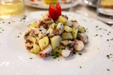 Tasty seafood salad with boiled octopus, potatoes, olive oil parsley served in Italian restaurant