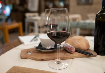 Dinner with glass of dry red wine in traditional Italian osteria restaurant