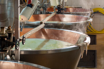 Process of making wheels of parmigiano-reggiano parmesan cheese on small cheese farm in Parma, Italy