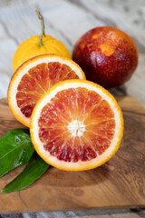 Sicilian sweet juicy yellow and red blood oranges with green leaves close up
