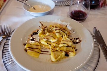 Italian food, fresh home made pumpkin stuffed pasta tortellini or ravioli dumplings with parmesan parmigiano reggiano cheese and Balsamico Vinegar of Modena, Parma, Emilia Romagna, Italy