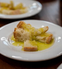 Tasting of Italian extra virgin olive oil with bread on organic farm in Tuscany, Italy