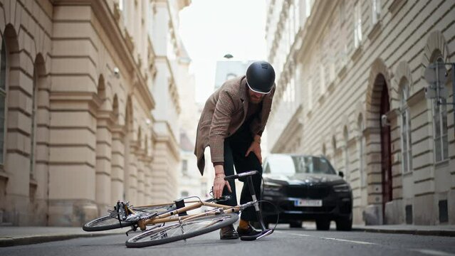  Bicycle accident in city. Man cyclist fell off road bike while cycling. Bike injurie, injured knee
