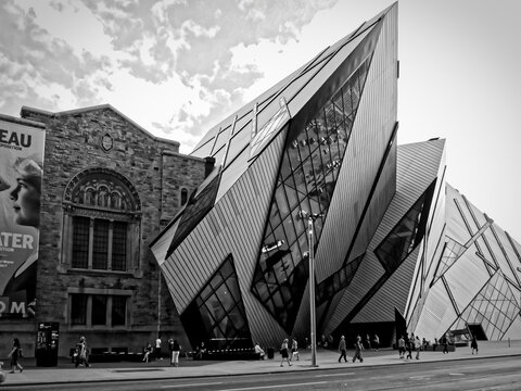 TORONTO, CANADA - 08 05 2011: Black and white image of famous modern Royal Ontario Museum buildig walking in front in a sunny day in Toronto on August 05, 2011.