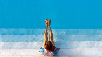 Top view of woman tourist enjoying the relaxation at the refreshing blue crystal clear swimming...