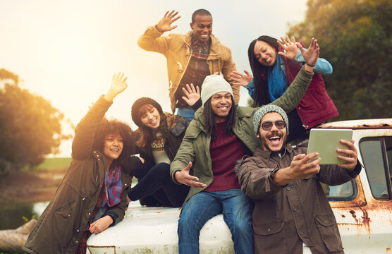 Hello social media, hello world. Shot of a group of friends posing for a selfie while having fun outside.