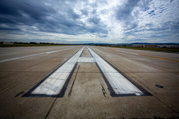 Airport runway landing and take off marks with clouds in the distance