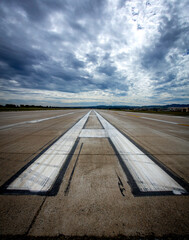 Airport runway landing and take off marks with clouds in the distance