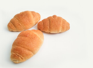 Three freshly baked croissants on a white background, with copy space