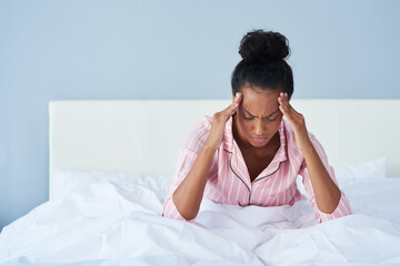 Getting a headache in the morning is the worst feeling. Shot of a young woman suffering from a...