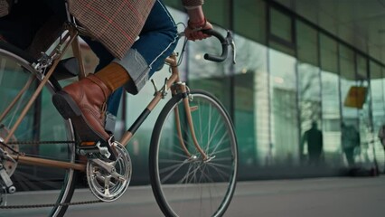 Midsection Close up leg shot of a businessman with bicycle commuting to the office. Modern building. Copyspace