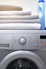 Flawless functionality for your laundry needs. Shot of a washing machine with folded towels and detergent on top of it.