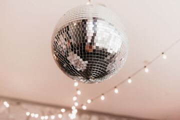 Disco ball in the New Year's interior on a pink background
