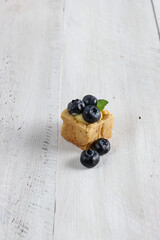 Small tartlet pastries topped with blueberry fruits.