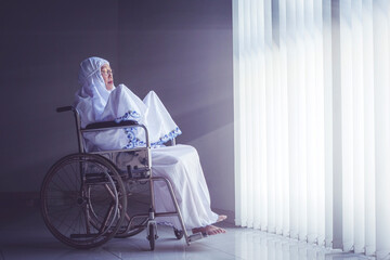 Senior woman praying to the Allah in wheelchair