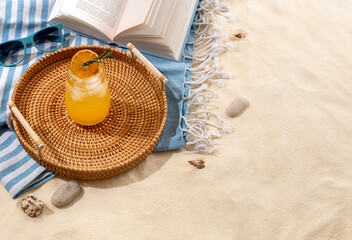 Tequila sunrise cocktail on a wicker tray on beach with white sand. Summer sea vacation and travel concept. Exotic summer drinks