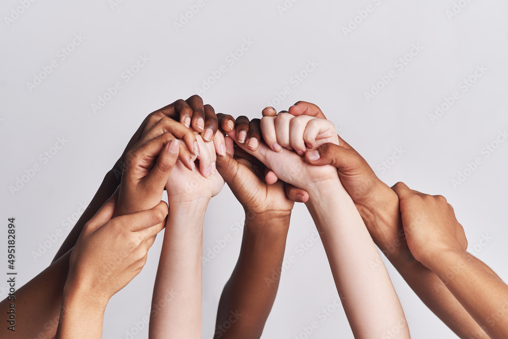 Poster diversified as a whole. shot of a group of hands holding on to each other against a white background