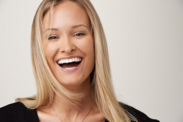 Laughter and happiness. A gorgeous young blonde woman smiling at the camera. - obrazy, fototapety, plakaty