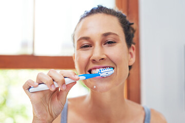 Dental hygiene is extremely important. Portrait of an attractive young woman brushing her teeth at home.