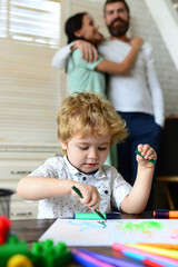 Fototapeta premium Happy family having fun, parents and little child playing together. Cheerful son drawing with father and mother enjoying spending time. Kid learning painting, little artist painting, drawing.