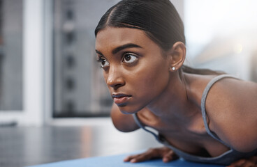 Winners never lose focus. Close up shot of an attractive young woman busy exercising on her gym mat at home.