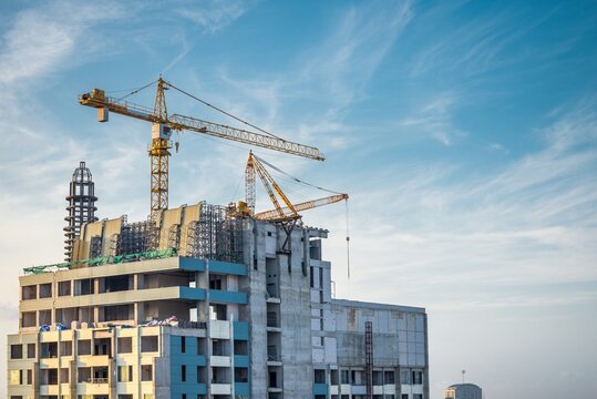 Modern building and tower crane in construction site. Construction industry concept. 