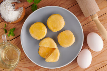 Chinese Dessert Traditional, Sweet Dessert Chinese Style, Asian Dessert. Plate of delicious homemade Chinese pastry with stuffed salted egg yolk lava, selective focus with a cup of tea.