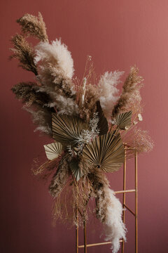 Boho composition with pampas grass and palm leaves on a terracotta wall
